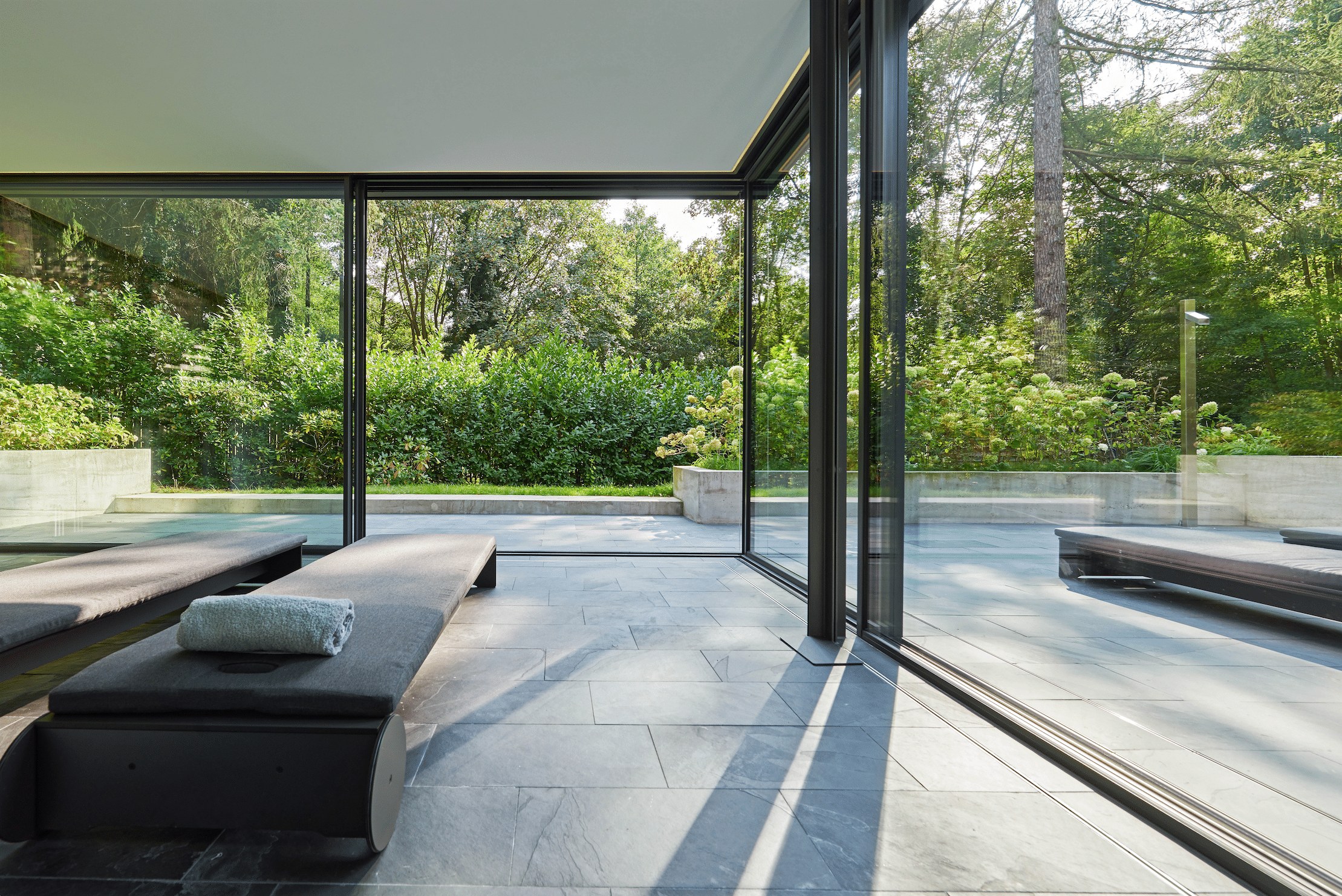 Wellnessbereich mit Terrasse und deckenhohen Glas-Schiebetüren von Solarlux.