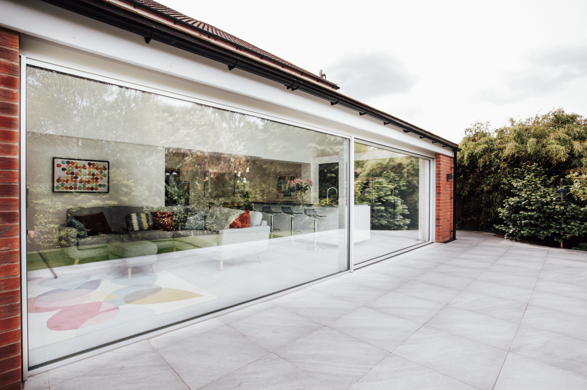 Backsteinhaus mit großzügiger Terrasse und deckenhohen XL-Schiebefenstern von Solarlux.