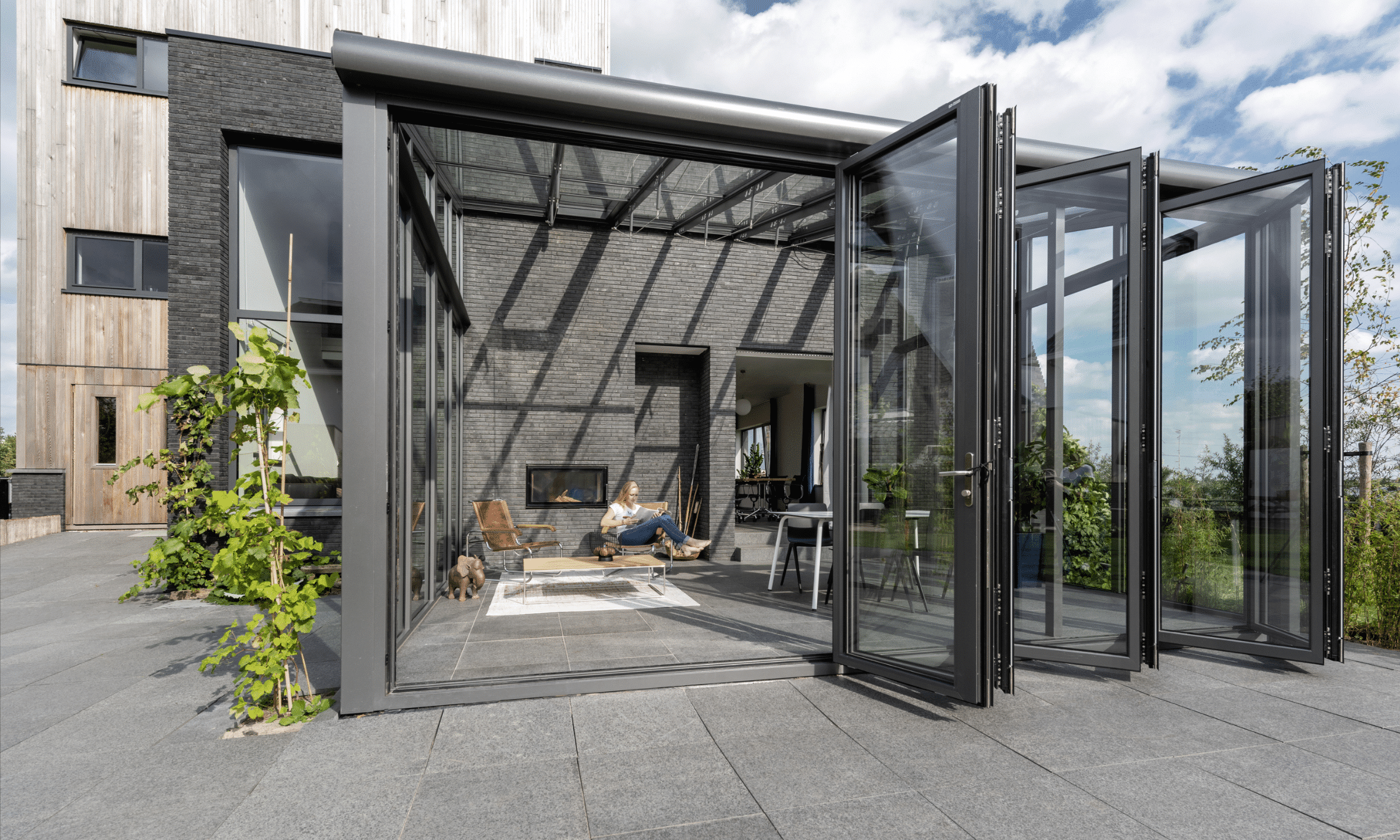 Wintergarten Anbau mit Panoramablick in den Garten dank deckenhoher Glasschiebetüren von Solarlux.