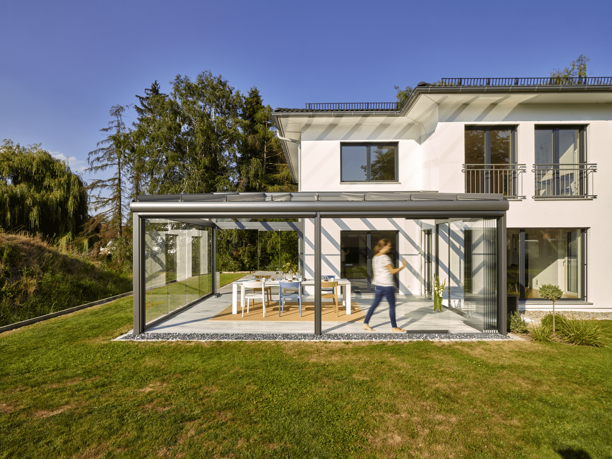 Atrium-Zubau mit rundum Verglasung, barrierefreiem Zugang zum Garten, deckenhohen Glasschiebetüren und einem Glas-Terrassendach von Solarlux.