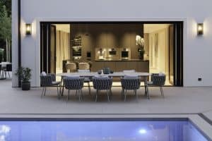 Grosse Küche, die durch Glasfaltwände von Solarlux barrierefrei mit der Terrasse verbunden ist.