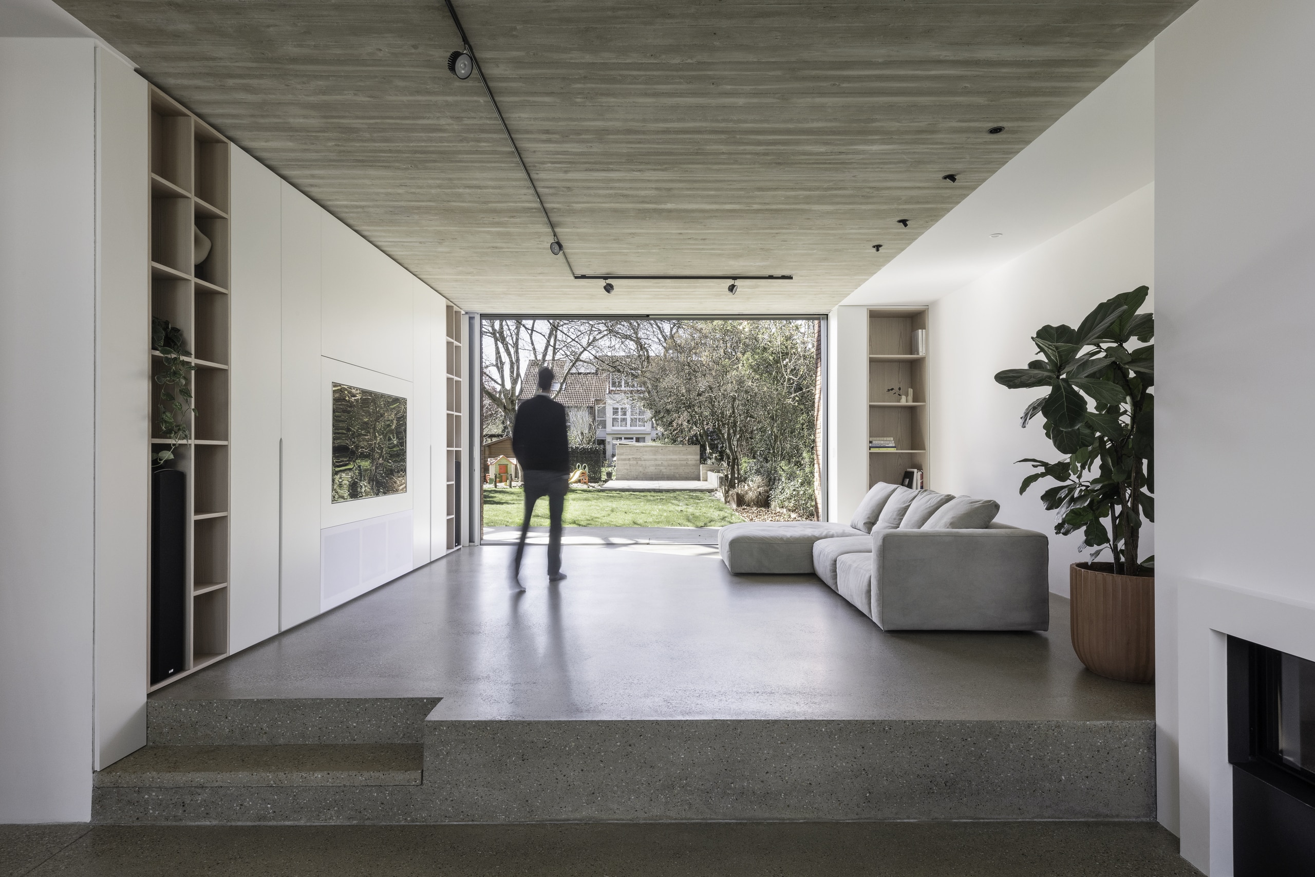 Grosses helles Wohnzimmer von dem man durch eine Glasschiebetür von Solarlux barrierefrei in den Garten gelangt.