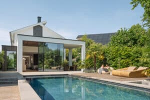 Ein modernes Einfamilienhaus schafft mit den großflächigen Schiebefenstern „Cero III“ mit ihrem unaufdringlichen schlanken Rahmen einen nahtlosen Übergang zwischen Innen- und Außenbereich mit Pool und stilvoller Gartengestaltung - von Solarlux.
