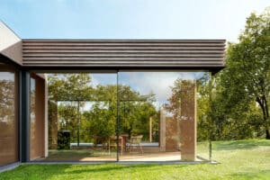 Ein modernes Gebäude mit Flachdach, großflächigem Schiebefenster Cero IV und eleganter Glasarchitektur von SOLARLUX.