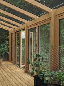 Durch die filigrane Dachkonstruktion des Systems SL Aura und den schmalen Profilansichten der großen Glas-Faltwände Woodline von Solarlux, die sich nach außen öffnen, ist der Raum lichtdurchflutet.