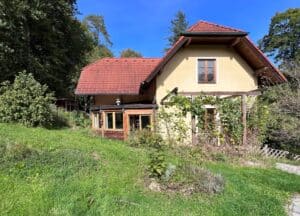 Solarlux präsentiert ein altes Einfamilienhaus, wie es vor der modernen Sanierung mit großem Terrassenbereich und Glasfaltwänden aussah.