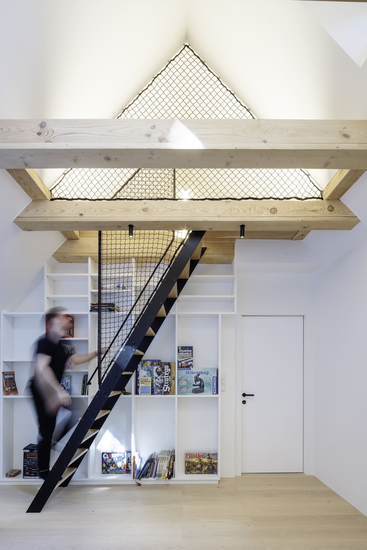 Solarlux präsentiert ein fertig saniertes Einfamilienhaus mit hellem offenem Dachstuhl, integriertem Bücherregal und einer offenen Treppenaufgang unter den lichtdurchfluteten Dachgiebel.