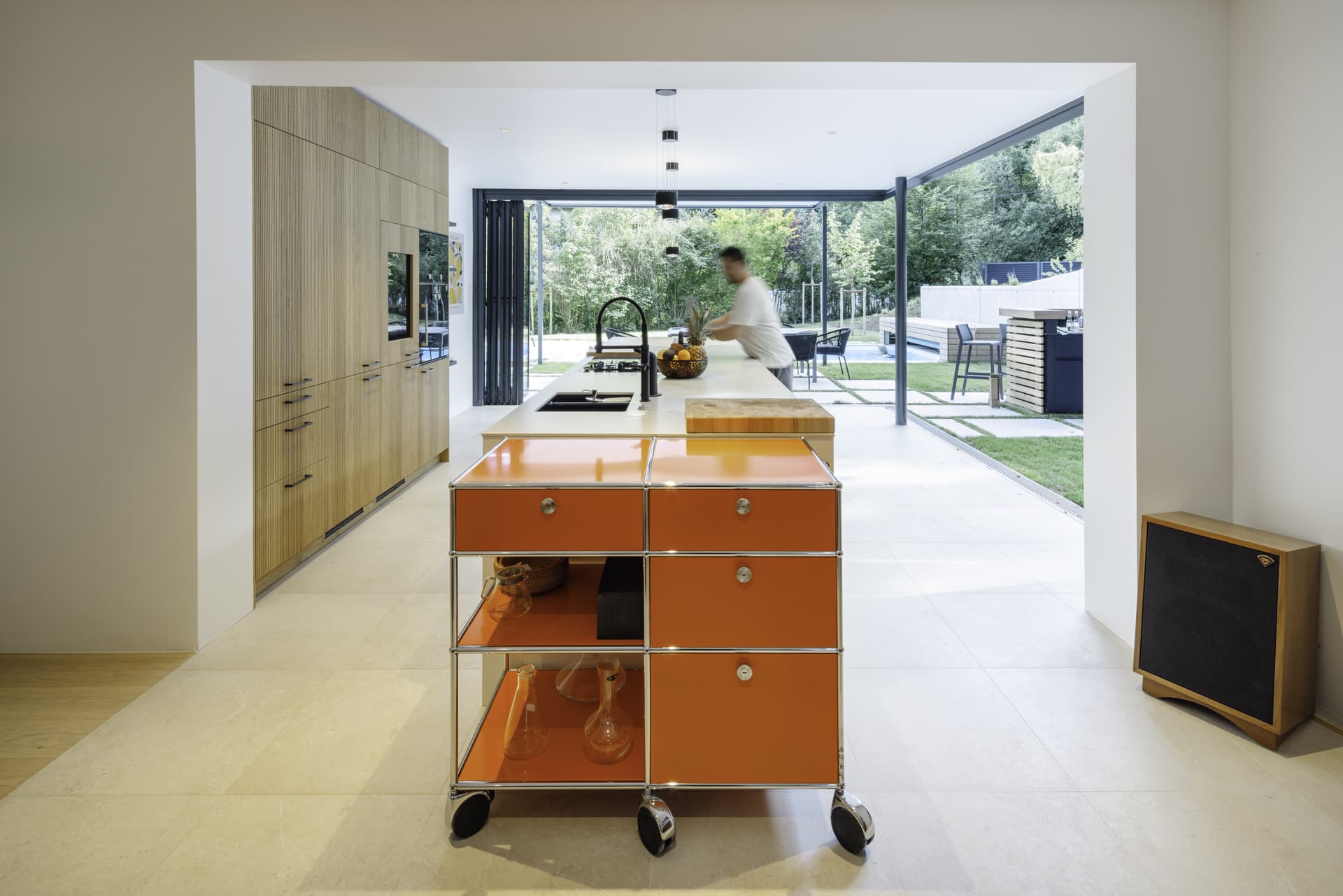 Solarlux präsentiert ein fertig saniertes Einfamilienhaus mit großer offenen Küche mit Glasfaltwänden an zwei Seiten, die zur Terrasse hin geöffnet werden können.