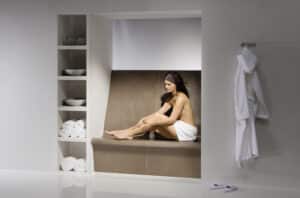 Frau auf einer Keramik-Wärmebank von Sommerhuber.