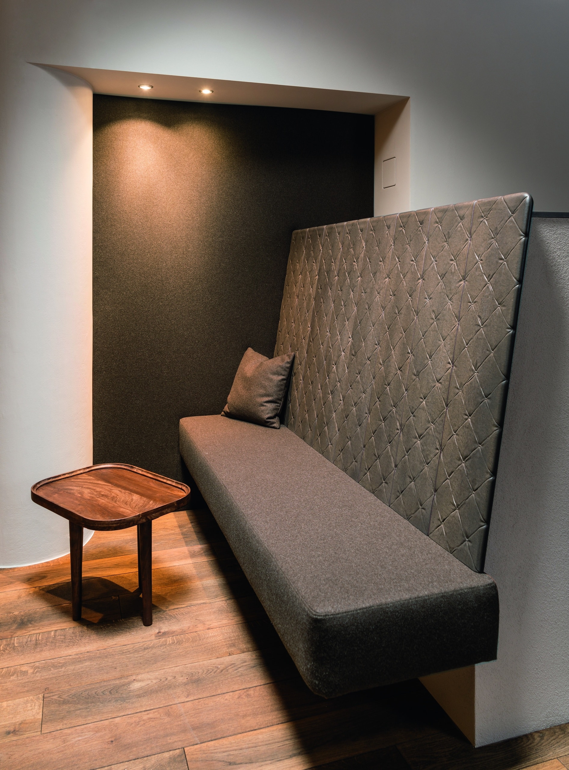 Sommerhuber zeigt gemütliche dunkelgrau geposterte Ofen-Sitzbank mit hoher Rückenlehne von Sommerhuber.