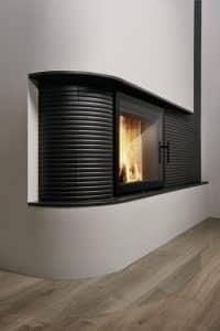 Kamin mit Verkleidung aus schwarzen Keramikmosaikfliesen in einem Stab und Rillendesign von Sommerhuber.