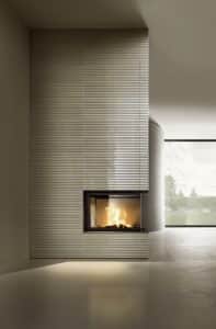 Kamin mit Verkleidung aus glänzend beigen Keramikmosaikfliesen in einem Stab und Rillendesign von Sommerhuber.