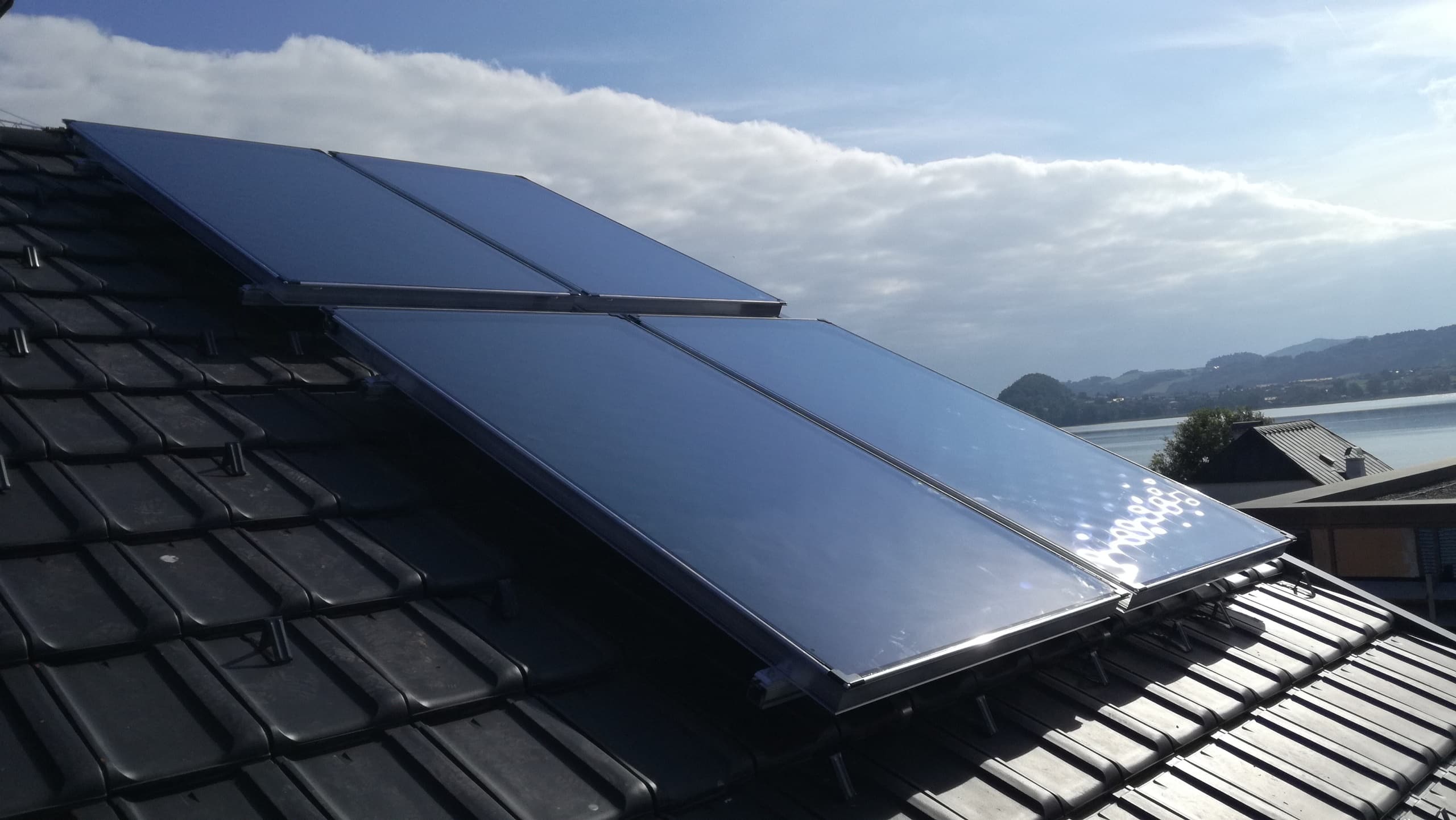 Ein Satteldach mit anthrazitfarbenen Schindeln und 4 großformatigen Photovoltaik-Modulen von Sonnenkraft.