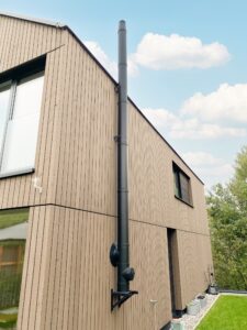 KombiLine DWD-Schott, die geprüfte Durchführung für Abgasleitungen und Rauchrohren von Heizungsanlagen mit Festbrennstoffen durch Decken, Wände und Dächer, aus brennbaren Baustoffen. Für das Bild wurde die Wandrosette der NiroLine DW 25 Abgasanlage kurzzeitig entfernt.
