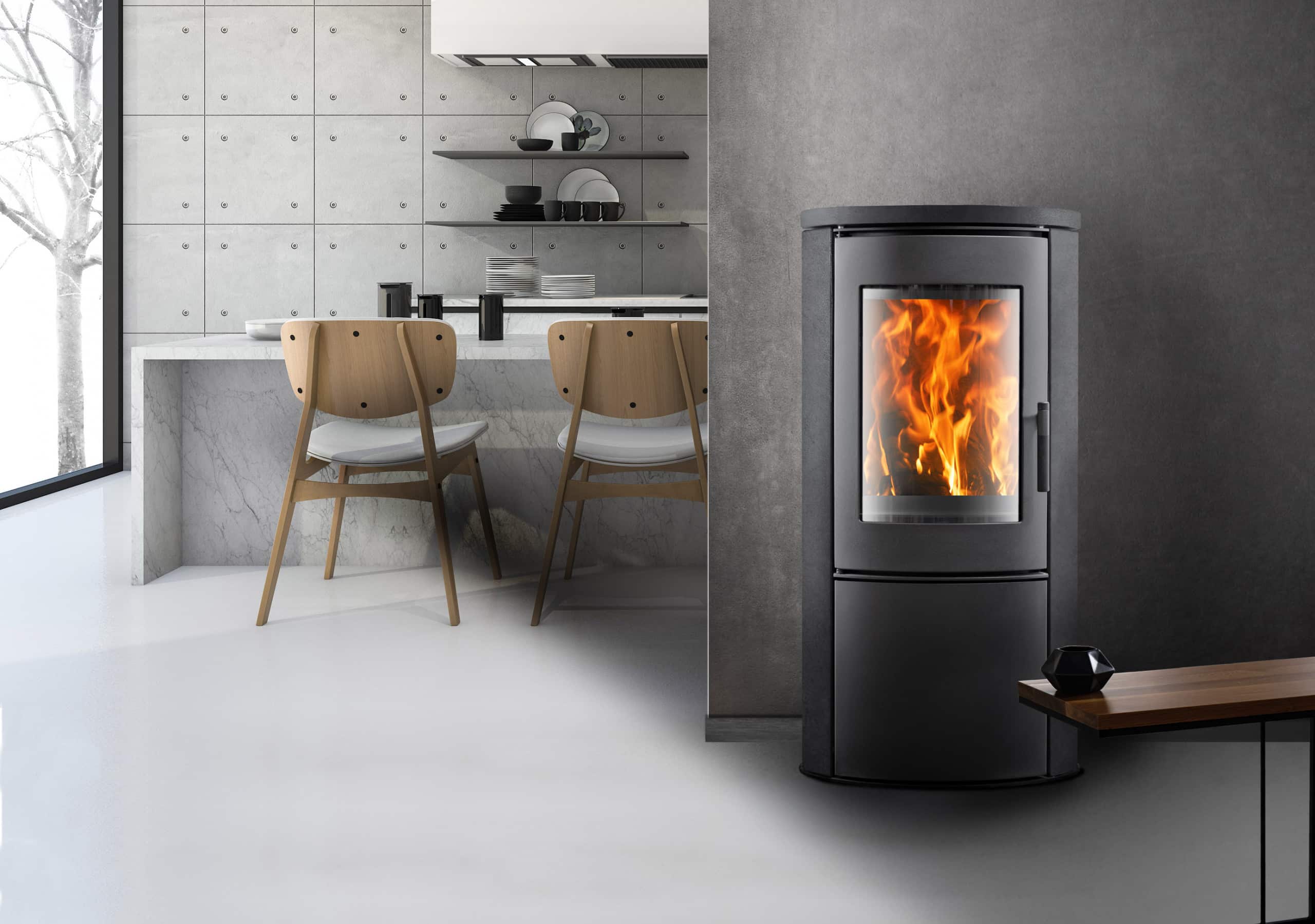 H. Stocker zeigt den HeatLine Kaminofen Bergisel (5,5 kW) in Anthrazit in einem Wohnraum.