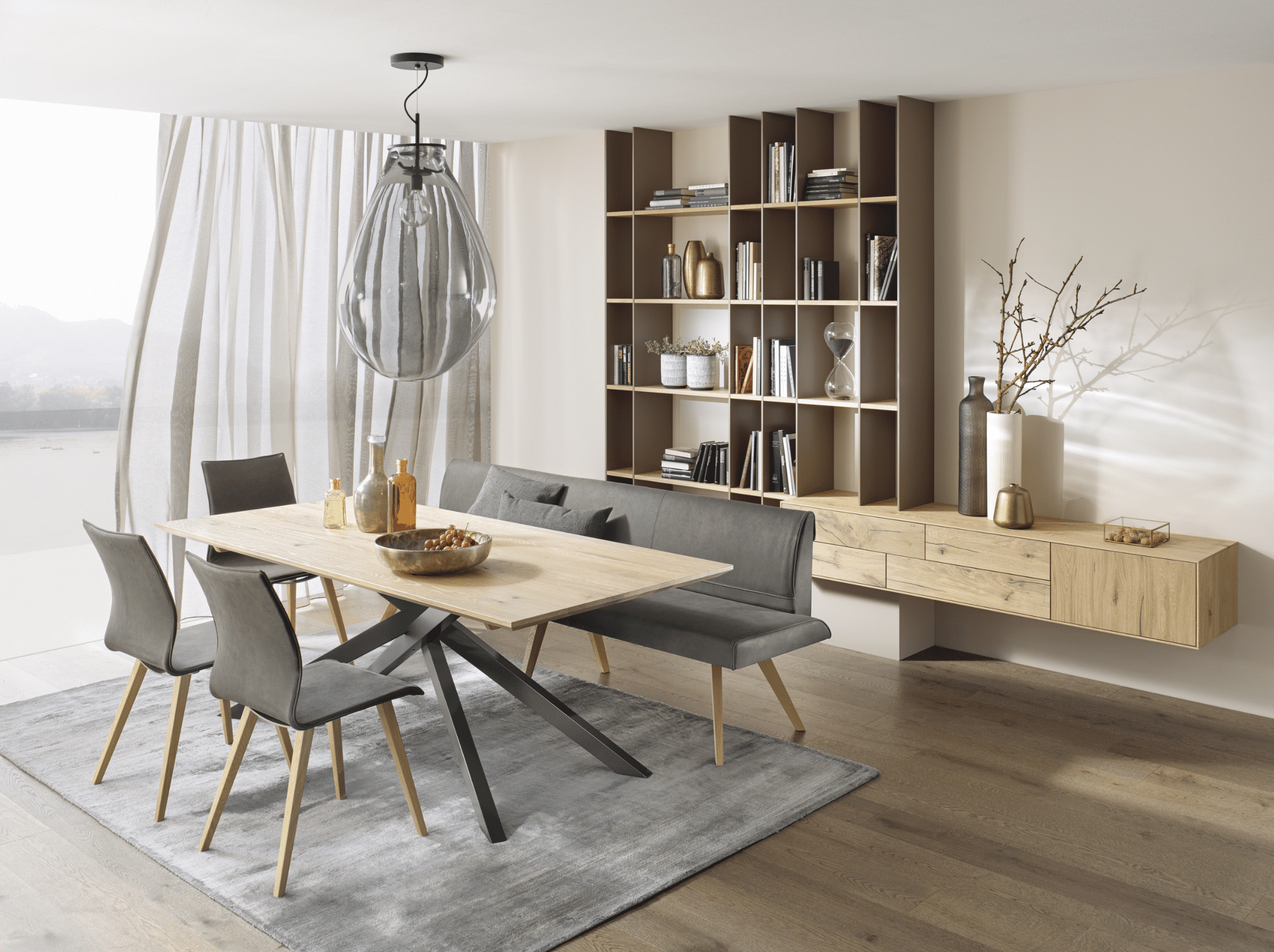 Tischlerei Bauer zeigt eine Essgruppe von ANREI mit modernem Esstisch aus dem Holz der weißen, gebürsteten Balkeneiche, Stühle mit Stoffebezug und Metallfüßen sowie serienidente Sideboards und Wandboards.