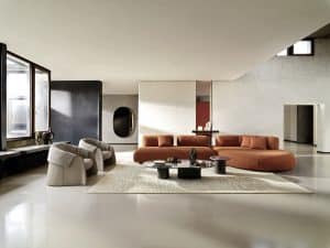 Bauer Tischlerei präsentiert Wohnlandschaft bestehend aus einer L-förmigen Couch mit Chaiselongue mit orangem Stoffbezug und zwei bequemen Sesseln mit Armlehne von Ditre Italia.
