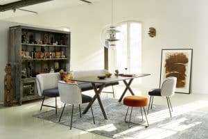 Bauer Tischlerei zeigt Esstisch aus dunklem Holz, Stühle und Sitzbank mit anthrazit und cremeweißen Stoffbezug und einen rustikalen Bücherschrank von haas Möbelwerk.