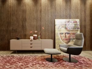 Bauer Tischlerei zeigt Sideboard im beigen Retro-Stil mit drei Schubladen und Lesesessel mit Fuss-Hocker mit Stoffbezug von haas Möbelwerk.