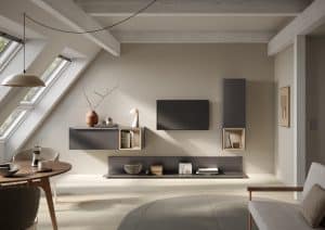 Bauer Tischlerei zeigt Wohnwand mit dunkelgrauen schmalen Wandschränken mit offenen Boxen und bodennahes Regal von Häcker Küchen.