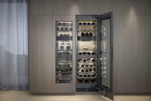 BAUER Tischlerei zeigt einen zweiflügeligen Einbau-Weinklimaschrank der Vario Kältegeräte Serie Expressive von Gaggenau der sich perfekt in den Wandverbau mit aschbraunen Holzfronten einfügt.