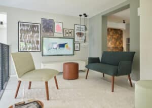 BAUER Tischlerei zeigt Sitzmöbel der Mobitec Kollektion SOFT SODA mit Holzgestell, einem dunkelgrauen Sofa und einem Polsterstuhl in Beige.