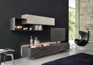 BAUER Tischlerei zeigt ein Wohnzimmer von SanGiacomo mit einem Medienmöbel mit dunkler Marmorfront und Regalen in einem Materialmix aus dunklem Holz und hellgrauem Holzwerkstoff.