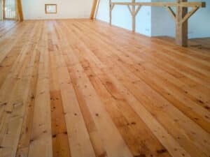 Ein ausgebauter Dachboden mit rustikalen Holzdielen und Holzfenstern von Tischlerei Penninger.