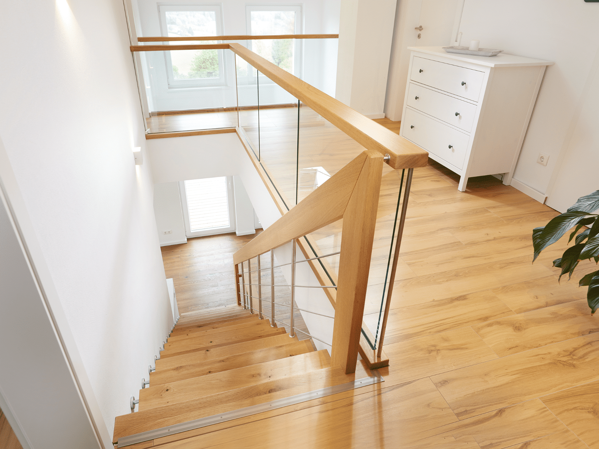 Treppenmeister zeigt Holztreppe mit Metallgeländer und Holzhandlauf.