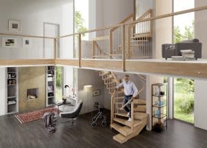 Ein Mann geht eine alters- und beeinträchtigungsgerechte Holztreppe mit zusätzlicher Halbstufe für besseren Treppenauftritt hinunter.