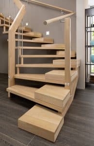 Holztreppe mit alters- und beeinträchtigungsgerechter zusätzlicher Halbstufe für besseren Treppenauftritt.