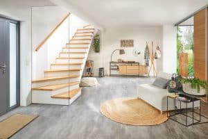 Eine Treppe mit Holzhandlauf, Holzauftritt, freizugänglichem Untertreppenstauraum und einer deckenhohen Glaswand am Treppenende von Treppenmeister.
