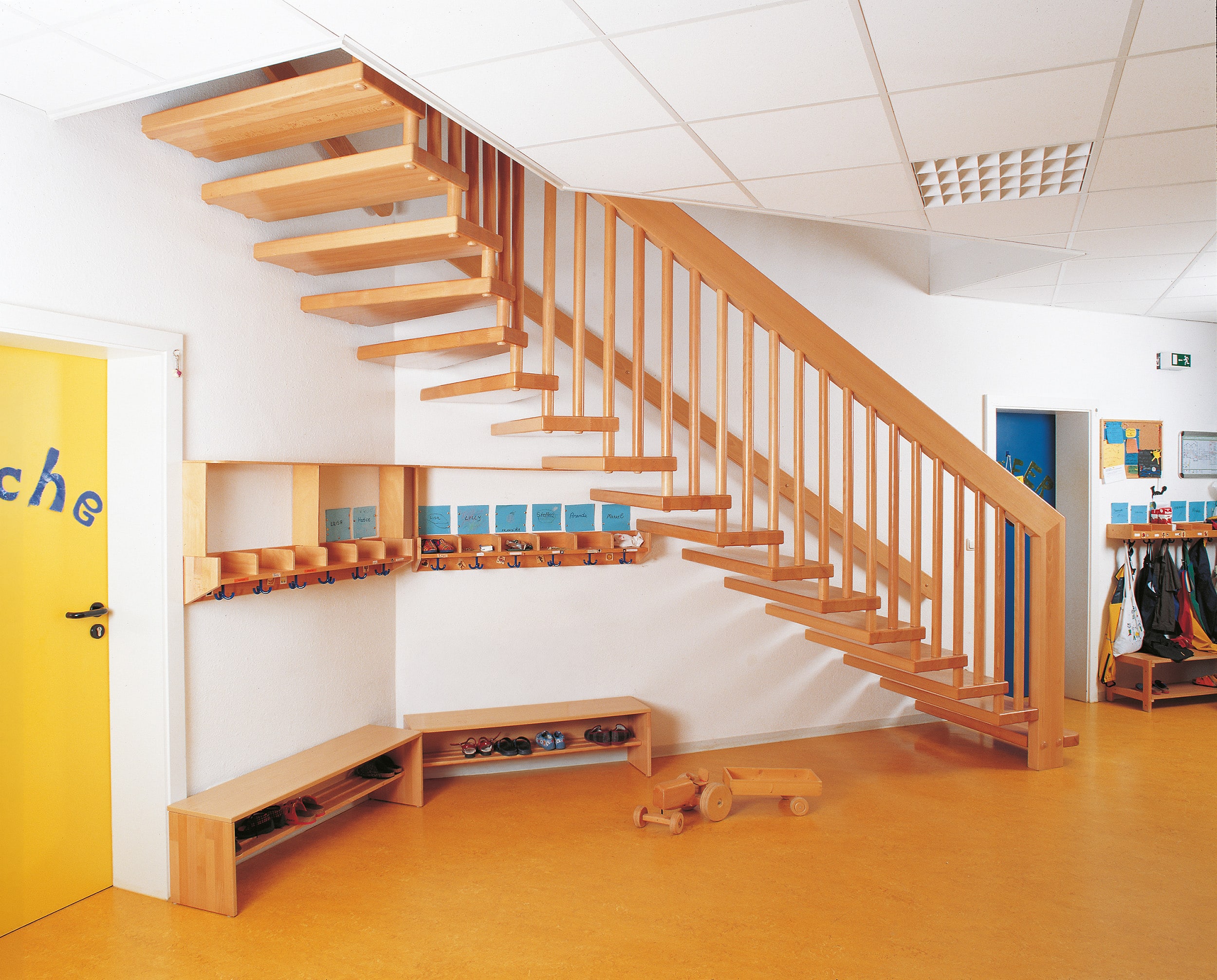 Bei der freitragenden Systemtreppe sind die Stufen nur an einer Seite an der Wand verankert. Ansonsten bezieht diese Konstruktion ihre Stabilität über das Geländer wie in dieser Schule/Kindergarten mit einer Holztreppe von Treppenmeister.