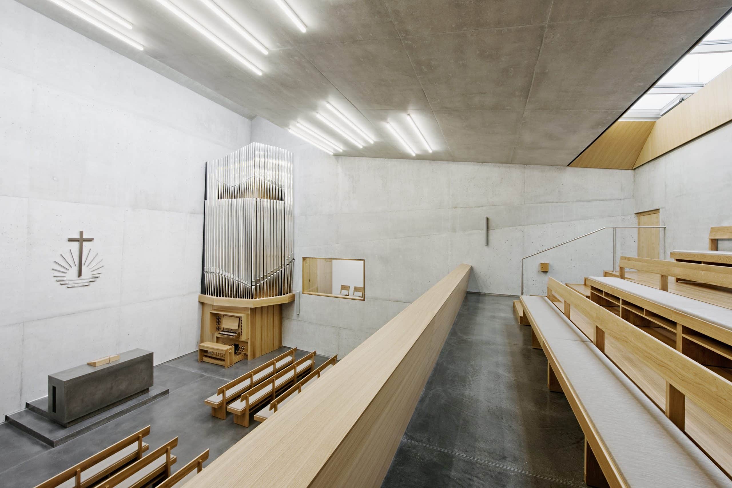 Blick von der Empore der Neuapostolischen Kirche in Wien Penzing mit Altar, Orgel und Sitzbänken.