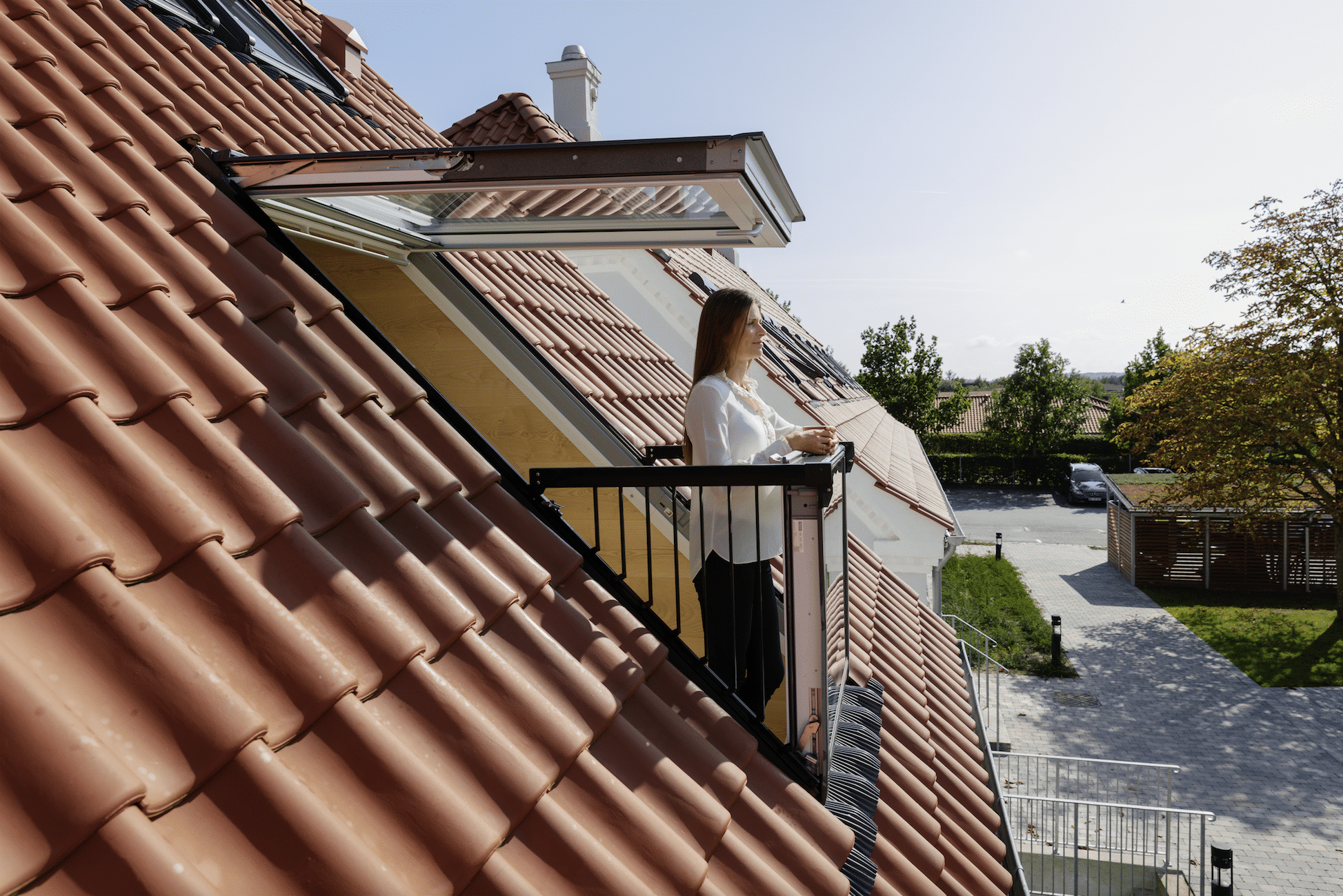 Frau auf ausklappbarem CABRIO-Dachbalkon von VELUX.