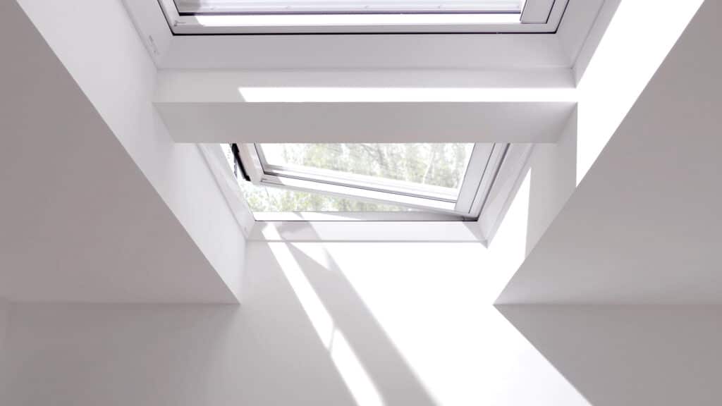 VELUX zeigt zwei Dachfenster auf einem Flachdach, die den Raum mit Licht durchfluten.