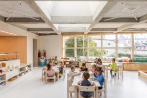 VELUX zeigt einen großen Speisesaal in einem Kindergarten, das mittels Dachfenster auf einem Flachdach hell und lichtdurchflutet ist.