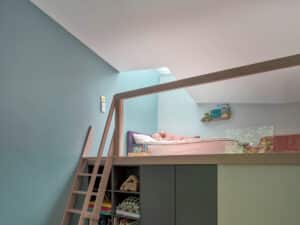 VELUX zeigt ein Kinderzimmer mit einem Bett auf einem begehbaren Schrank, das mittels Dachfenster auf einem Flachdach hell und lichtdurchflutet ist.