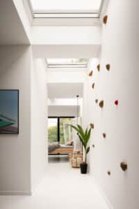VELUX zeigt einen Wohnraum mit Gang, der mittels Dachfenster auf einem Flachdach hell und lichtdurchflutet ist.