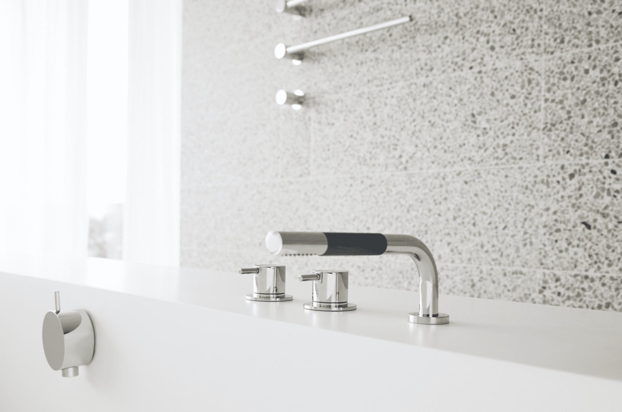 Badewanne mit Armaturen aus glänzendem Chrom von VOLA.