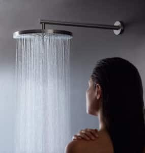 VOLA präsentiert eine große runde Regendusche aus mattem Chrom an der Wand montiert.