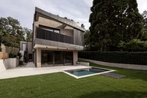 VOLA präsentiert eine moderne Villa mit Flachdach, Balkon, Terrasse, Glasfront, Pool und Garten.