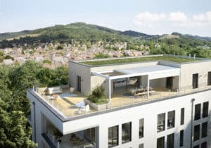 Ein Mehrparteienhaus mit Flachdach, Dachbegrünung und Dachterrasse mit einer weissen Pergola mit einem halb-offenem Lamellendach von Warema.