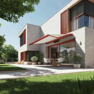 Eine Flachdachvilla mit großzügigem Außenbereich, einer Terrasse mit Betonfliesen und einer rotgerahmten Markise aus weissem Stoff - passend zu den roten Fenster, Türrahmen und Fassadenelementen der Villa - von Warema.