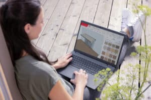 Eine Frau konfiguriert Sonnenschutzlösungen mit dem WAREMA Konfigurator am Laptop.