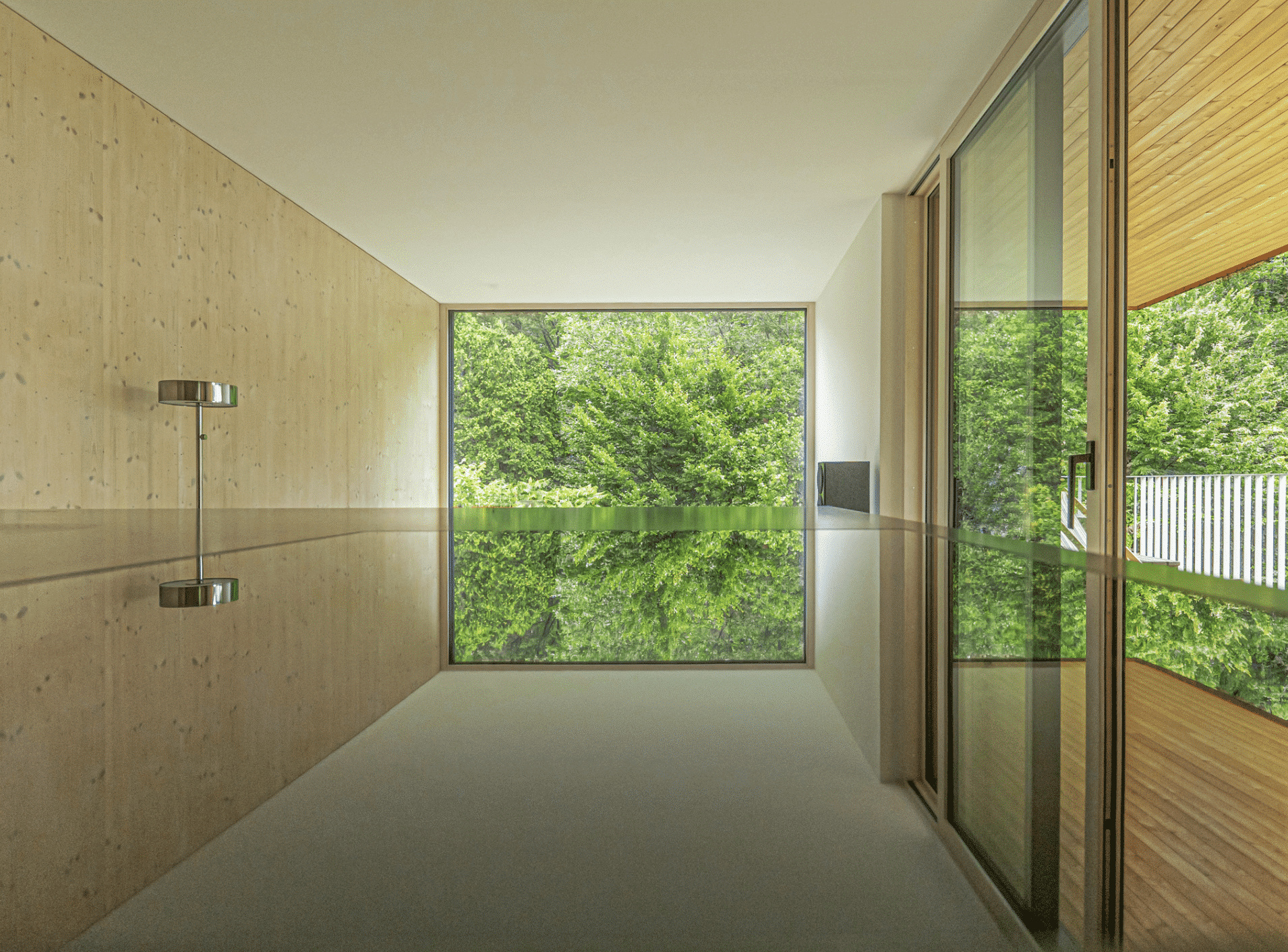 Weissenseer Holz-System-Bau zeigt Arbeitsplatte mit Blick auf die bodentiefe vollverglaste Front in einem Holzriegelhaus.