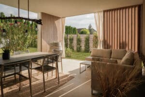 Eine gemütliche Terrasse mit Outdoor-Möbeln, Lamellen‑Sichtschutz und überdachtem Sitzbereich — elegant arrondiert von Weissenseer.