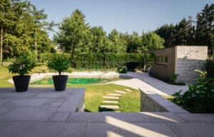 Holzterrasse mit Naturpool und Gartenanlage samt Außendusche ruhig und elegant von Weissenseer.