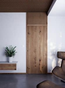 Moderner Wohnraum im 60er/70er-Jahre Look mit Sichtestrich, Design-Loungestuhl in braunem Leder, einem schwebendem Wandboard und einer rustikalen Eichentüre mit passender Türklinke in Übergröße und einem mit der Deckenvertäfelung optisch verbundenen Zargenquerteil in Sprossenoptik von WIENTÜR91.
