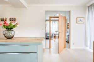 Küche mit einem großen Wandelement aus Glas mit einer Innentür aus Holz und passender Zarge von WIENTÜR91.
